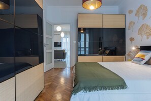 A modern bedroom with a bed, a seating area, and a view of the city. - Ginkgo House by Wonderful Italy (Turin)