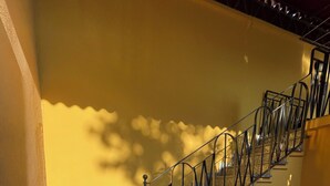 A staircase with a metal railing, stone steps, and a yellow wall. - 75sqm apartment in villa (Cinisello Balsamo)