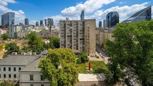 A high-rise building with a modern architectural design, surrounded by other buildings and trees. - Warsaw Central Apt - 9th Floor, Balcony, Tram&Bus - by Rentujemy (Warszawa)