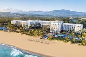 A beachfront hotel with multiple buildings, palm trees, and a pool area. - LAS BRISAS @ RIO MAR RESORT (Río Grande)