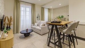 Un salon moderne comprenant un canapé, une table basse et un coin repas avec des chaises.