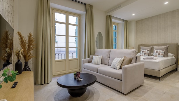 Un salon moderne avec un canapé, une table basse et un lit.