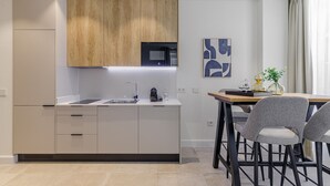 Una cocina moderna con una isla central, electrodomésticos integrados y un comedor con mesa y sillas.