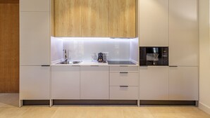 Une cuisine moderne équipée d’un four encastré, d’une machine à café et d’un four à micro-ondes.