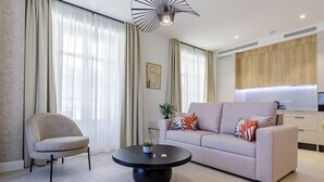Een moderne woonkamer met een bank, fauteuil en een ronde salontafel.