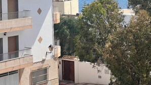 Ein Küstengebäude mit rotem Ziegeldach, einem Balkon und Meerblick.