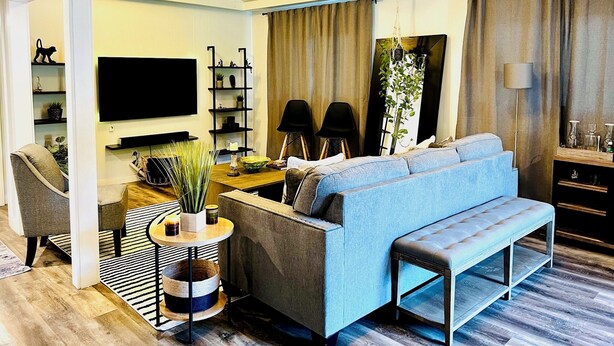 A modern living room with a blue sofa, a wooden coffee table, a TV, and a bookshelf. - Family home in Dallas’s most prestigious neighborhood - Preston Hollow! 3 BR/2BA (Dallas)