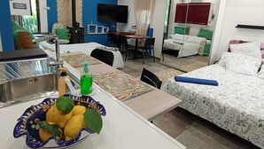 Ein modernes Hotelzimmer mit Küchenzeile, Essbereich und einem separaten Schlafzimmer.