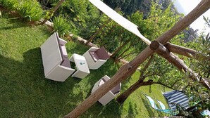 Ein Garten mit weißen Korbmöbeln und einer Reckschaukel.