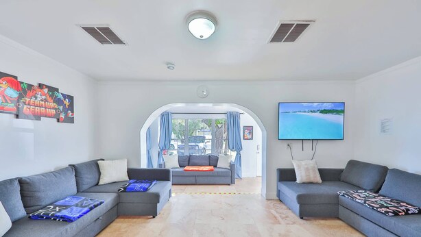 A modern living room with two grey sofas, a flat-screen TV, and artwork on the walls.