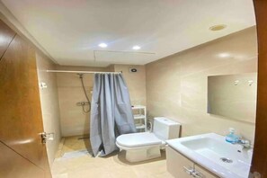 Een douche, handdoeken, zeep, toiletpapier