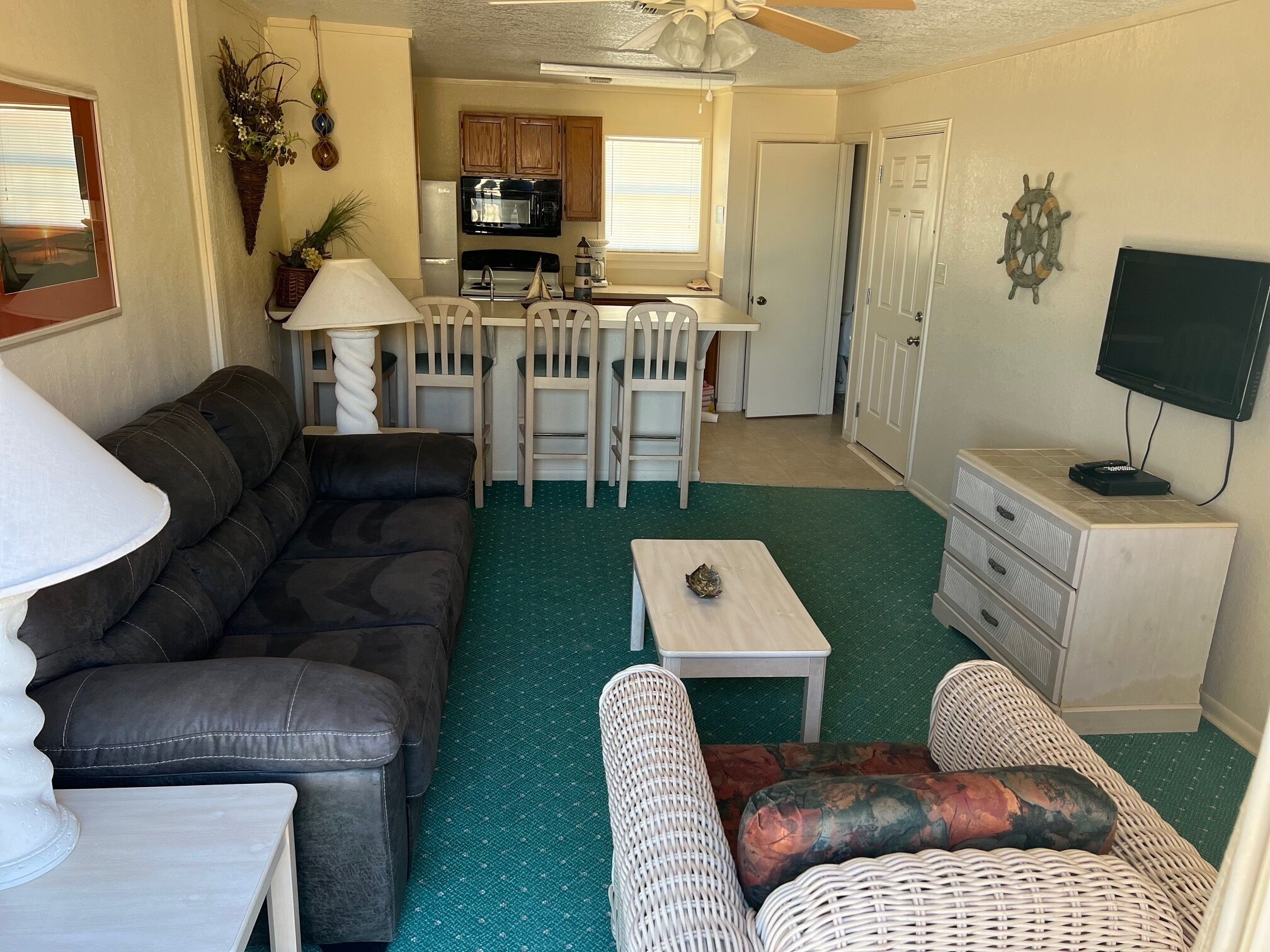 A compact living space with a sofa, a small dining table, a coffee table, and a TV on a cabinet.