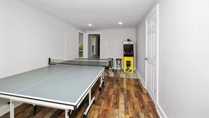 Une pièce équipée d’une table de ping-pong, d’un petit coin salon et d’un distributeur automatique.