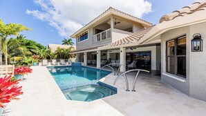 Et toetagers hus med swimmingpool, udendørs siddepladser og en overdækket patio.