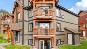 Un immeuble à plusieurs étages doté d’un balcon et d’une petite structure adjacente.