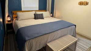 A bedroom with a canopy bed, a bedside table with a lantern, and a wall-mounted TV. - Waterfront Multi-family Retreat (Crystal River)