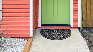 A house with a green door, a red siding exterior, and a wooden fence. - Waterfront Multi-family Retreat (Crystal River)