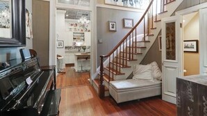 A spacious living room with a grand piano, a staircase, and a cozy seating area. - Charming 2-bedroom apartment with AC, WiFi in wonderful New Orleans (New Orleans)