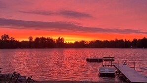 A sunset view over a calm lake with a dock and chairs on the shore. - Lake Life! (Wautoma)