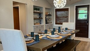 A dining area with a wooden table set for four, surrounded by upholstered chairs. - Lake Life! (Wautoma)