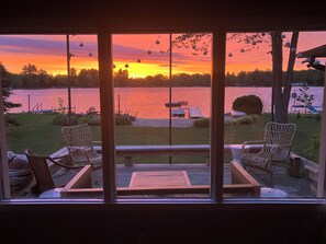 A view from a room with large windows overlooking a lake at sunset. - Lake Life! (Wautoma)