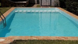 A rectangular swimming pool with a tiled edge and a metal ladder on one side. - Apartment 2 min walk from cabo negro beach. (Tetouan)