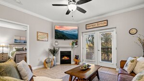 Una sala de estar con chimenea, ventilador de techo y un letrero que dice 'Great Smoky Mountains'.