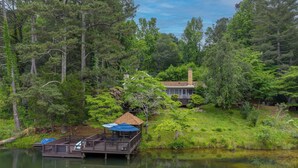 A cabin with a dock extending into a lake, surrounded by dense forest. - Lakeside Country Cottage (Talking Rock)