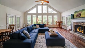 A spacious living room with a large sectional sofa, a fireplace, and a television. - Lakeside Country Cottage (Talking Rock)