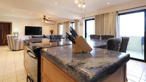 A modern kitchen with granite countertops, a built-in oven, and a knife block. - A-409 Enjoy Your Vacation In This Exquisite Condominium! (Cabo San Lucas)