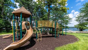 Un parque infantil con tobogán, estructuras para escalar y un pabellón.