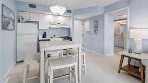 A modern kitchen with white cabinets, a central island, and a chandelier. - Beautiful 1-bedroom condo with the best views ocean,back bay & beautiful sunset (Fort Myers Beach)