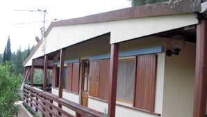 A building with a wooden deck and a covered area with windows.
