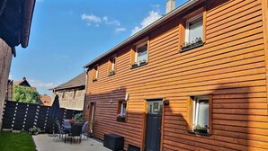 Et træhus med terrasse, dør og vinduer.