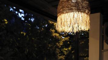 An outdoor seating area with a table, chairs, and a hanging light fixture.