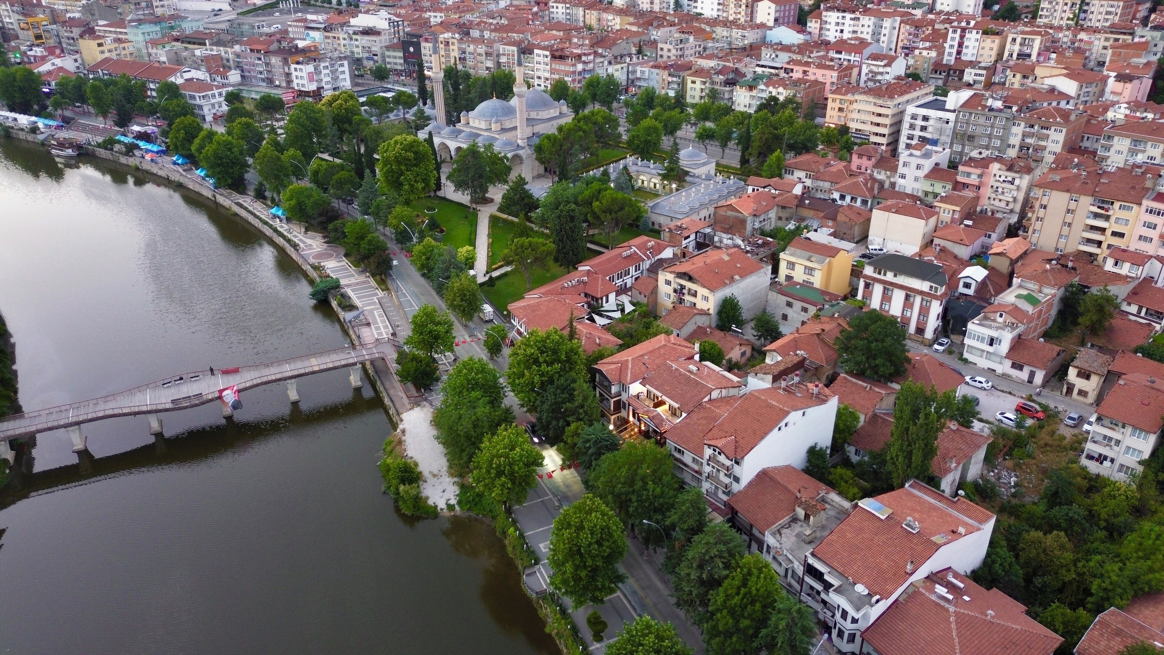 Luftaufnahme einer Stadt mit einem Fluss, einer Brücke und dichter Wohnbebauung.
