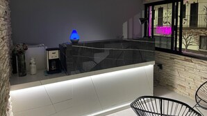 A modern kitchen with a marble countertop, a blue LED lamp, and a window with a neon sign.