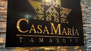 A sign with the name "CASAMARIA TAMASOPO" on a stone wall.