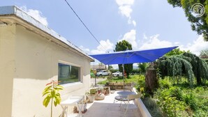 A patio area with a blue umbrella, outdoor seating, and a small garden. - ESCALE - LA MOTTE SERVOLEX (LA MOTTE SERVOLEX)