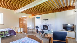 A cozy room with two beds, a dining table, chairs, a TV, and a fireplace. - ESCALE - LA MOTTE SERVOLEX (LA MOTTE SERVOLEX)