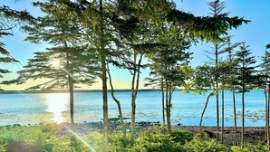 A natural landscape with a body of water, trees, and a rocky shoreline. - ⭐NEW⭐ Stunning Beachfront Living w/ Gameroom & Firepit Near Acadia  (Gouldsboro)