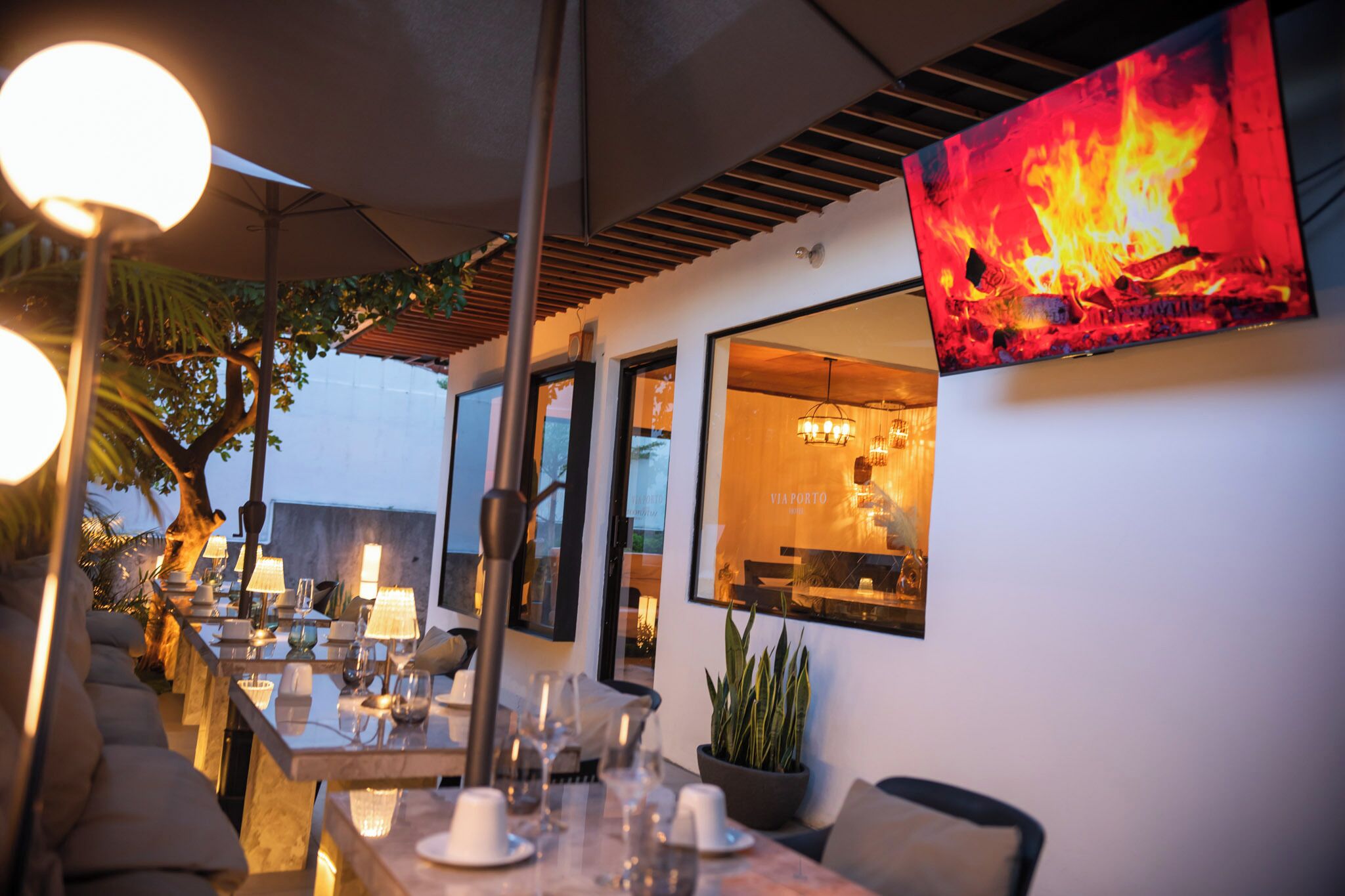 An outdoor dining area with tables, chairs, and ambient lighting.