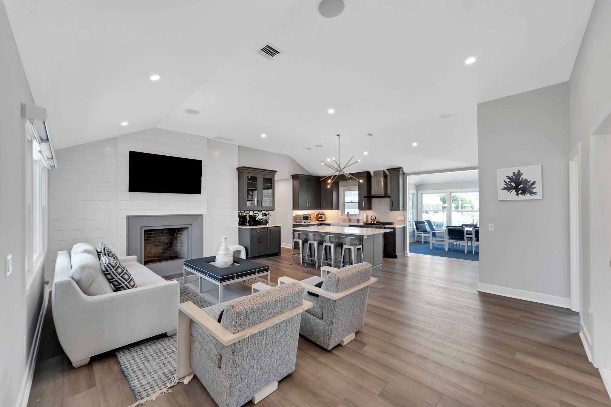 A spacious living room with a fireplace, a dining area, and a kitchen with a large island.