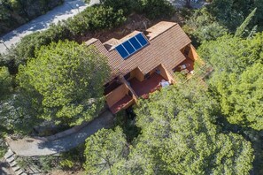 Una casa con techo inclinado, un panel solar y un camino de entrada pavimentado.