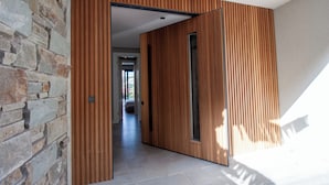 Un intérieur moderne avec un mur en pierre, un lambris en bois et un sol carrelé.