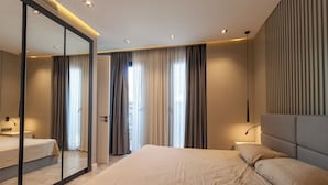 Une chambre d’hôtel moderne avec un grand lit, un miroir et une vue sur l’extérieur.