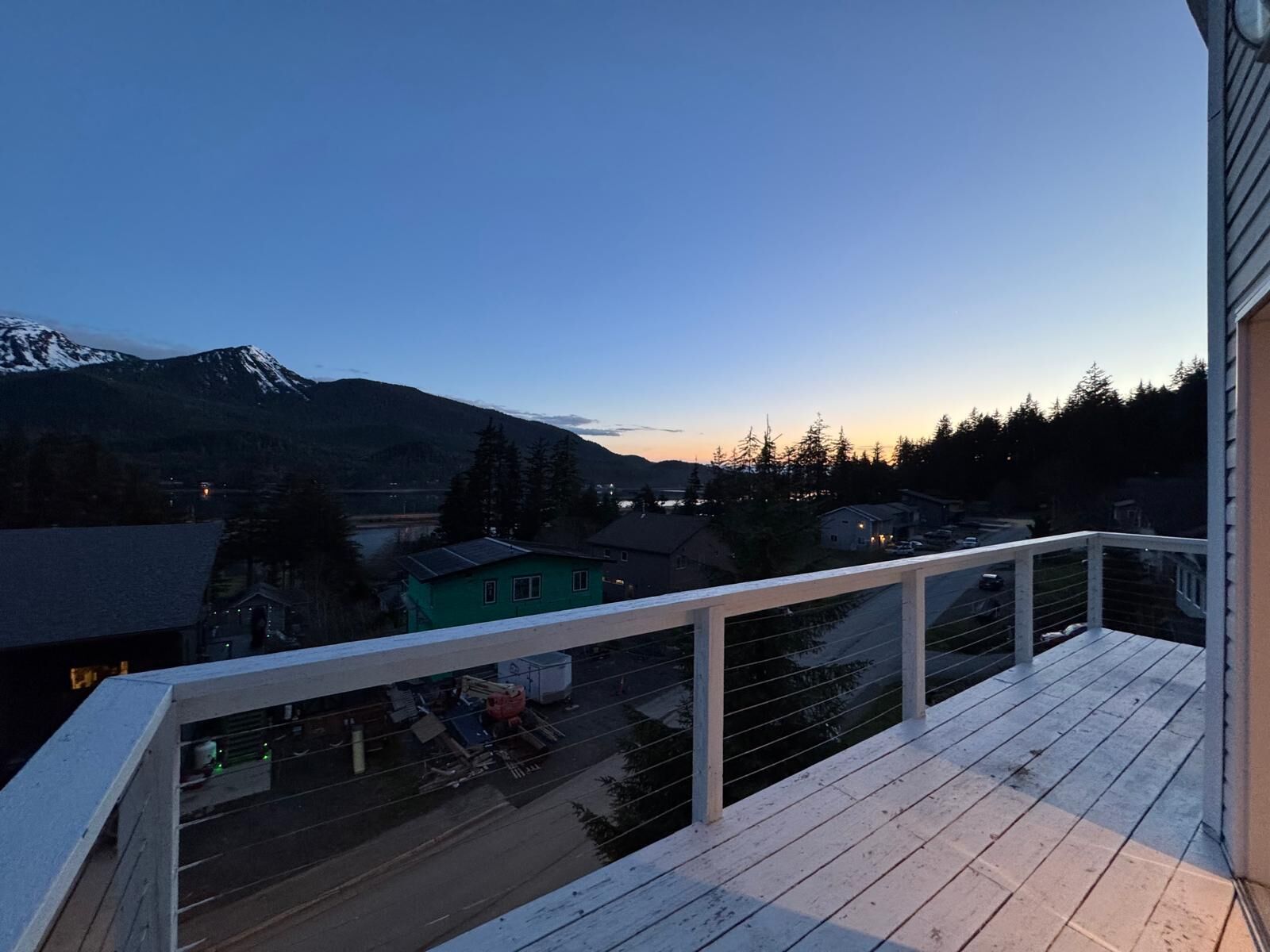 A balcony with a view of a town and mountains.