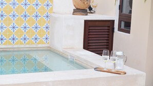 A pool area with a tiled wall, a wooden door, and a tray with glasses and a pitcher. - Casa Copán: Colonial charm in downtown Merida (Mérida)