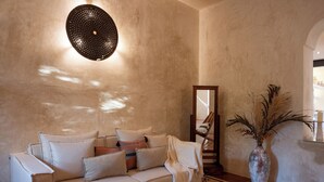 A cozy living room with a sofa, a coffee table, a vase with dried plants, and a wall-mounted light fixture. - Casa Copán: Colonial charm in downtown Merida (Mérida)