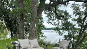 Een terras met een bank, stoelen en een bijzettafeltje.